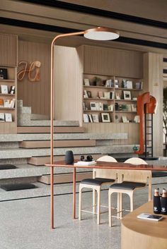 a living room filled with lots of furniture and bookshelves next to a staircase