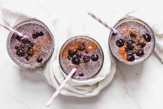 three glasses filled with blueberries and orange juice