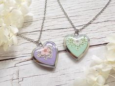 These handmade heart shaped lockets feature a variety of wildflowers on their covers.  The lockets close with a strong hidden clasp and hang on an 18 inches long stainless steel chain. All lockets are made of stainless steel and are hypoallergenic.  Pendant length: 25 mm Pendant width: 22 mm Materials used: epoxy resin, real pressed flowers, stainless steel locket and chain (Please note that all the flowers included are natural and there might be small differences or imperfections in their shape and colour tone.) Heart Necklace Silver, Tiny Heart Necklace, Necklace Photo, Heart Photo, Heart Locket Necklace, Handmade Heart, Green Jewelry, Photo Locket, Silver Lockets