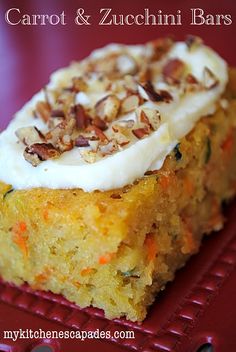 carrot and zucchini bars with cream cheese frosting on a red cooling rack