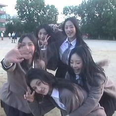 a group of young women standing next to each other on top of a sandy beach