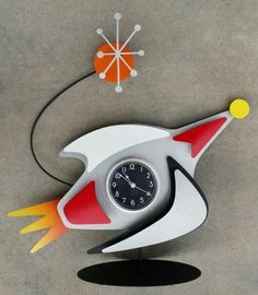 a clock that is on the ground with an object in the air next to it