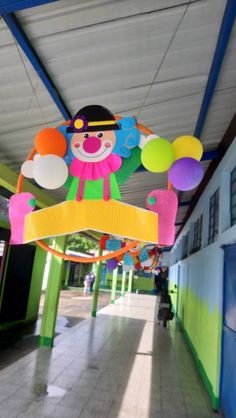 the entrance to an indoor play area with balloons and clowns hanging from it's ceiling