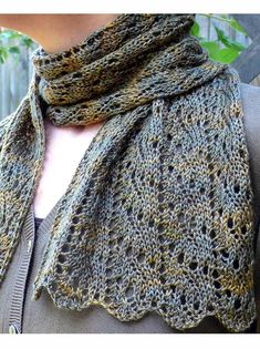 a woman wearing a gray sweater with a crocheted shawl on her neck