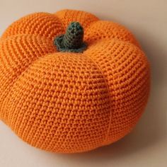 an orange knitted pumpkin sitting on top of a table