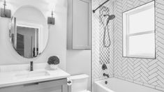 a bathroom with a sink, mirror and bathtub in black and white photo taken from the doorway