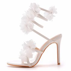 a white high heeled shoe with flowers on the side