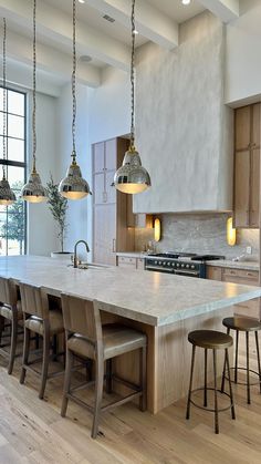 a large kitchen with an island in the middle and lots of stools around it