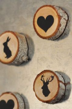 three pieces of wood with black heart and deer heads on them, sitting next to each other