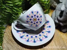 a tea cup and saucer sitting on top of a white plate next to green plants