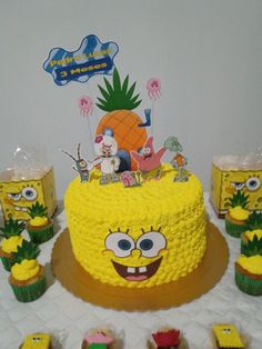 a spongebob themed birthday cake surrounded by cupcakes and other decorations on a table