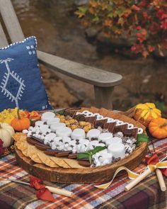 a table topped with lots of food on top of a wooden tray next to a bench