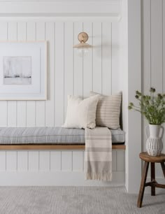 a room with white walls and wood paneling on the wall is decorated in neutral tones