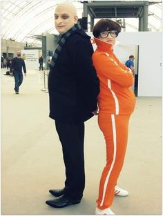 two people dressed in orange and black standing next to each other with their arms around one another