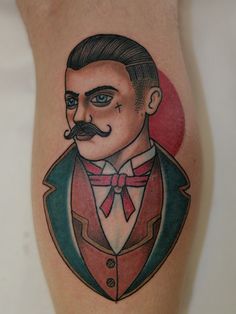 a man with a mustache and suit on his leg is wearing a red bow tie