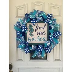 a blue and white wreath with the words find me by the sea on it