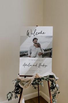 a welcome sign sitting on top of a wooden easel in front of a wall