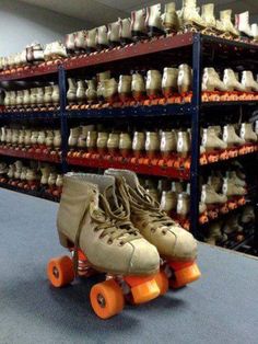 two roller skates sitting on the floor in front of shelves