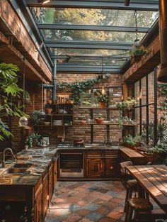 an indoor kitchen with brick walls and lots of potted plants on the counter top