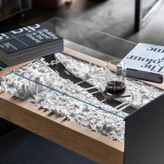 a glass table topped with books and a vase filled with liquid sitting on top of it