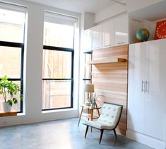 a living room filled with furniture and large windows