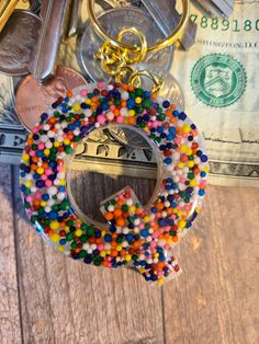 a close up of a keychain on a table with money in the background