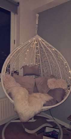 a white hanging chair with some pillows on it