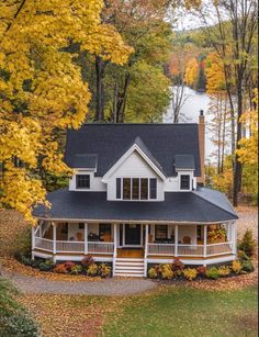 a white house surrounded by fall foliage and trees