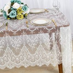 the table is set with white and blue flowers