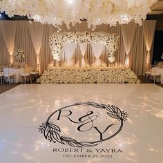 the dance floor is decorated with white flowers and greenery