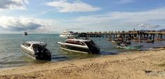 two boats in the water near a pier