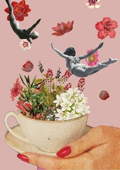 a woman's hand holding a cup with flowers and birds flying around