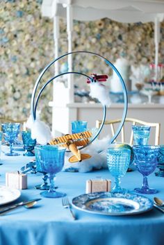 a table set with blue glassware and plates