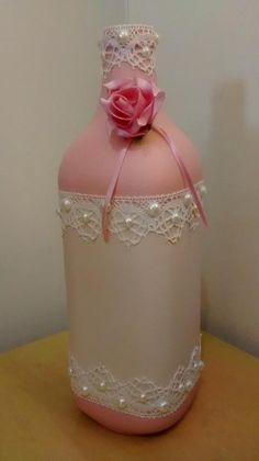 a pink bottle with lace and a flower on it