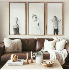 a living room filled with furniture and pictures hanging on the wall above it's coffee table