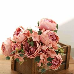 a bouquet of pink flowers sitting on top of a wooden box