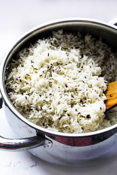 a pot filled with white rice on top of a stove