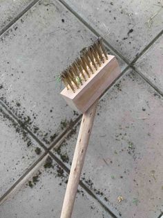 a wooden brush sitting on top of a tiled floor