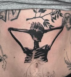 a woman's back with tattoos on her body and the image of a skeleton