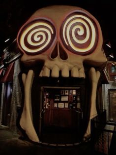 a large fake skull sitting in the middle of a building with eyes and mouth open