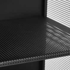 the shelf is black and white with some light coming through it's mesh covering