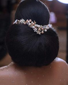 the back of a woman's head wearing a hair comb with pearls on it