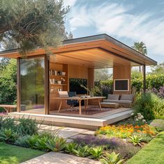 an outdoor living area with furniture and flowers in the foreground, surrounded by greenery