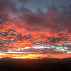 the sun is setting behind some clouds in the sky