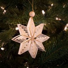 a wooden snowflake ornament hanging from a christmas tree