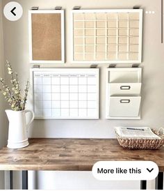 a wooden desk topped with lots of white drawers next to a wall mounted bulletin board