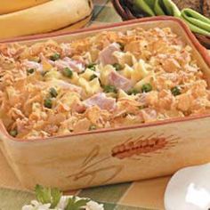 a casserole dish with ham, peas and cheese in it on a table