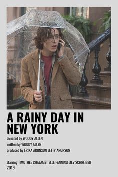 a man holding an umbrella and talking on the phone in front of a poster for a rainy day in new york