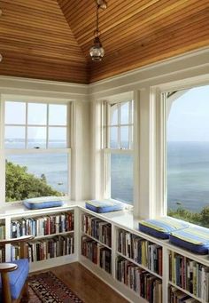 an image of a room with bookshelves and ocean view in the background on instagram