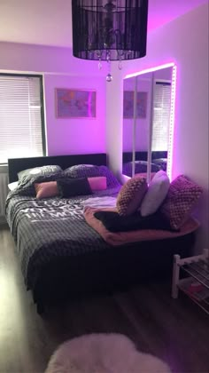 a bedroom with purple lighting and black bedding